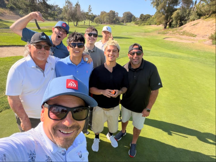 Group wearing PEAK hats on golf course